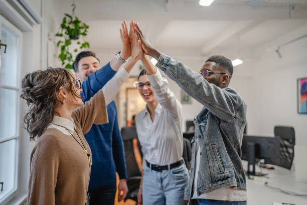 istock Positive motivated multicultural colleagues raise their hands together 2196627039