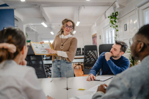 istock young businesswoman representing statistics to her work team 2196628970