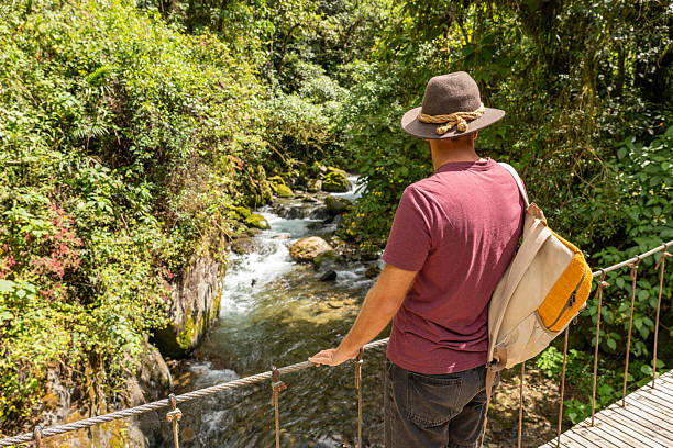istock Man Enjoying a Scenic Walk on Forest Bridge 2196629831