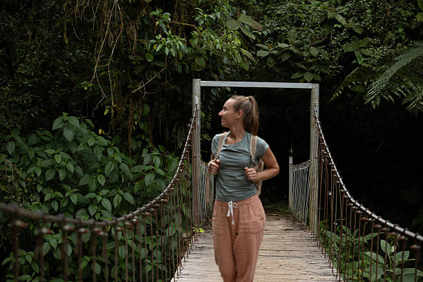 istock Woman Exploring Jungle Suspension Bridge 2196629931