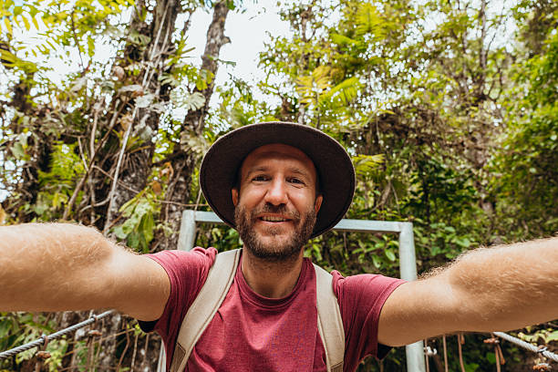 istock Adventurous man taking a selfie on a hiking trail in lush forest 2196629973