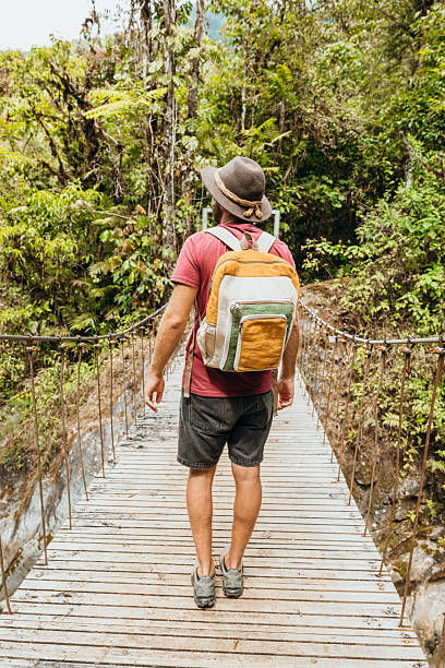 istock Adventurous Hiker on Rope Bridge in Lush Forest 2196629999