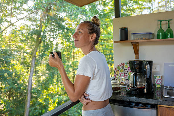 istock Woman Enjoying Morning Coffee in Rustic Kitchen 2196632637
