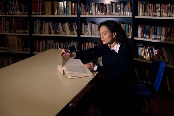 istock Woman studying diligently at a desk in a quiet library environment 2196634686