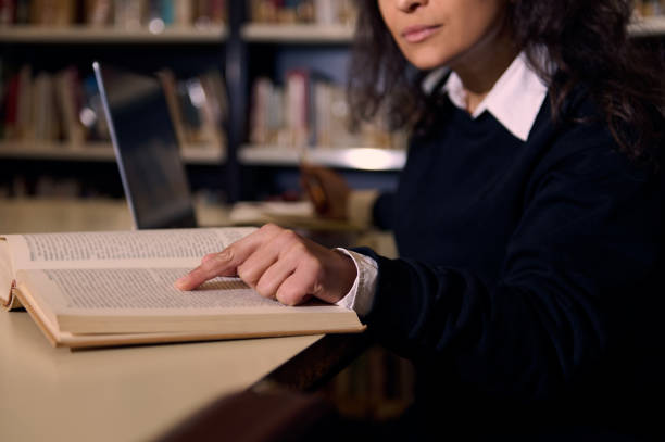 istock A person reading and pointing to a book in a library setting 2196634689