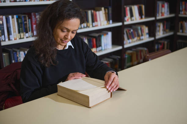 istock Woman reading a book in a quiet library environment 2196637307