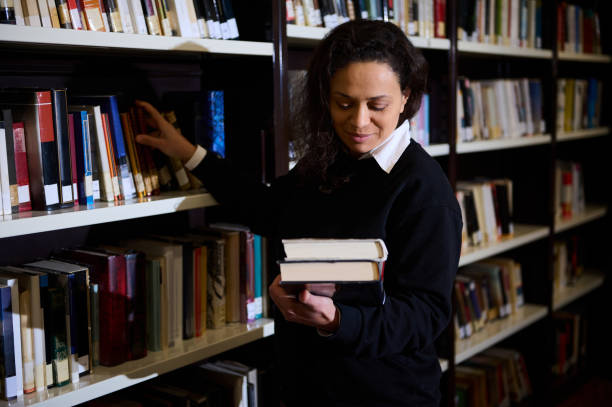 Woman browsing library shelves and selecting books for reading