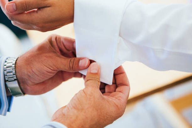 istock a man putting on the cufflinks on a white shirt 2196638777