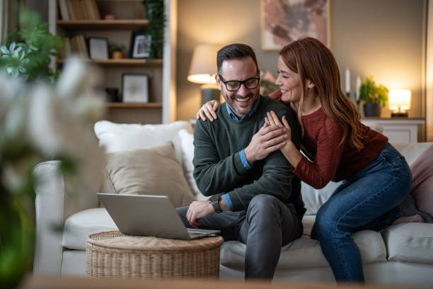 istock Young couple browsing the internet from their living room sofa 2196642041