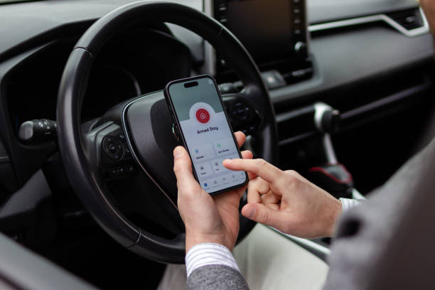 istock Businessman activating car alarm system with smartphone app inside vehicle 2196643971