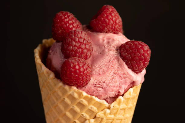 istock red raspberry ice cream in a waffle cone on a black background 2196645118