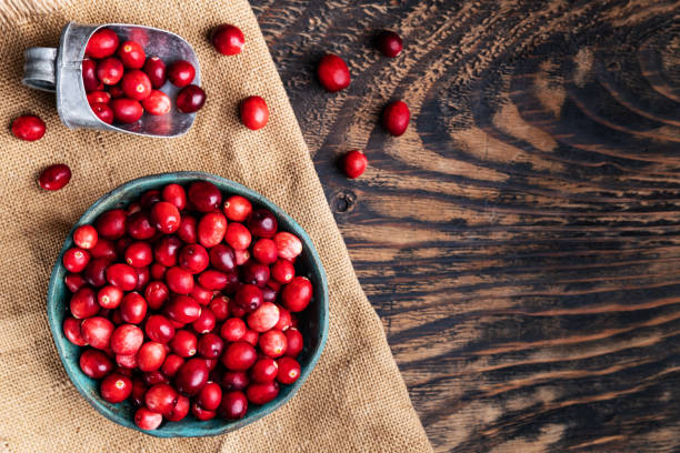 istock Fresh cranberries in wooden bowl on dark wooden table. View from above.Space for text. 2196647601