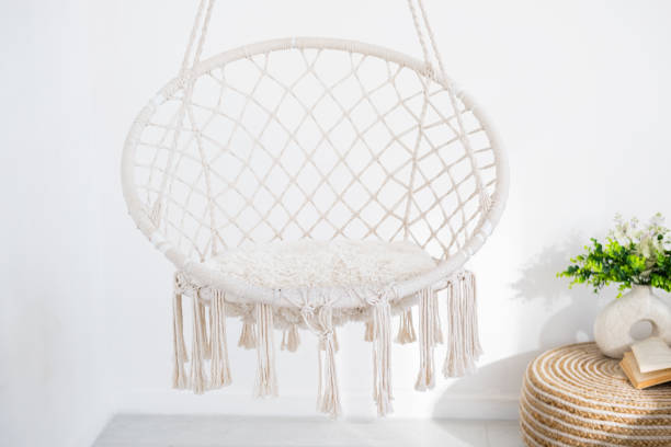 istock Hanging macrame chair in bright room with decorative plants and textures 2196653491