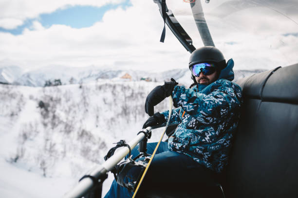istock Man with Snowboard sitting on a Ski lift 2196653722