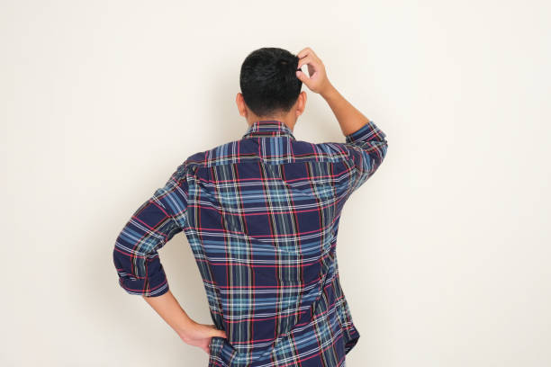 Back view of a man scratching his head showing confused expression