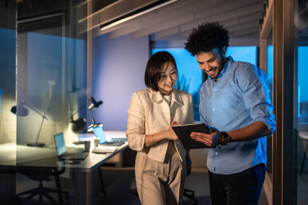 istock Diverse Business Executives Collaborating on Tablet After Hours 2196661262