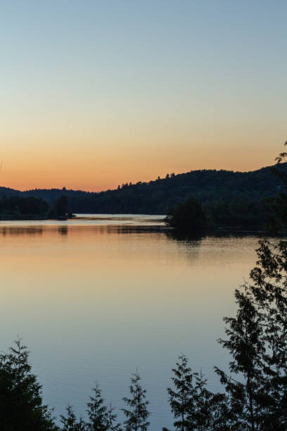 istock Serene Lakeside View at Sunset with Calm Waters and Distant Hills 2196661962