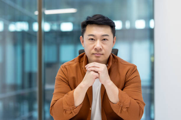 istock Asian man mature businessman posing confidently in a modern workplace environment 2196663372