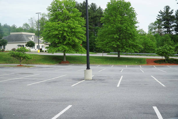 istock empty parking lot with spring green trees outside 2196668969
