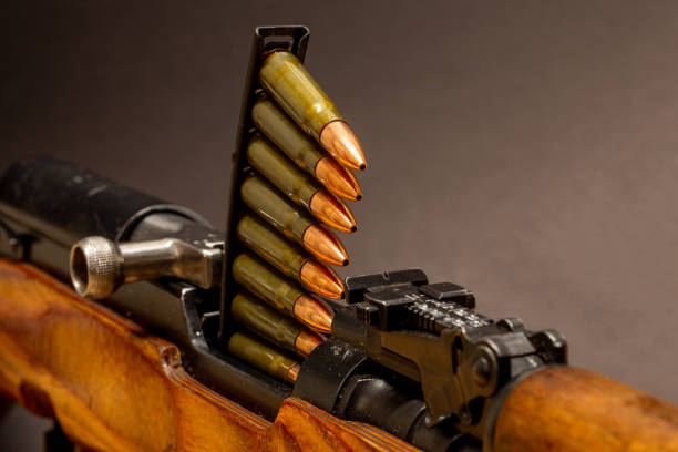 A close-up view of a classic semi-automatic rifle with a stripper clip loaded with rifle cartridges. Russian SKS
