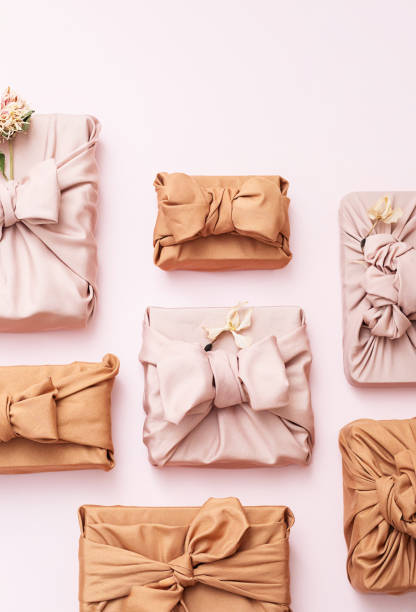 istock Presents wrapped in fabric scatted on pink. 2196669692