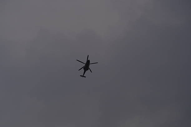 Silhouette of a flying helicopter in the sky