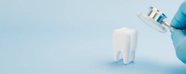 istock Dentist Day features a doctor using a stethoscope on a tooth model against blue 2196674020