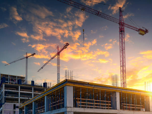 istock Several high-rise cranes against the backdrop of a beautiful sunset sky. 2196675940