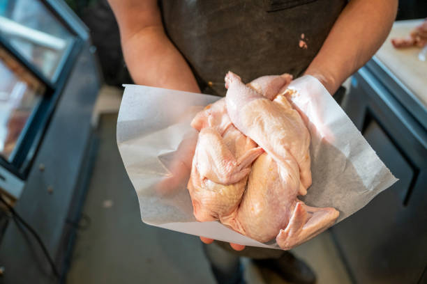 istock Butcher holds free-range chicken pieces 2196676485