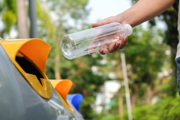 istock Woman's hand holding a water bottle and throwing plastic bottles into the trash for disposal. Types of plastic waste and recycling. environmental concept 2196679017
