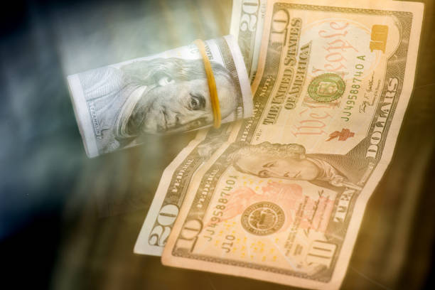 Benjamin Franklin portrait on a 100 dollar roll with different American money - Light movement effect