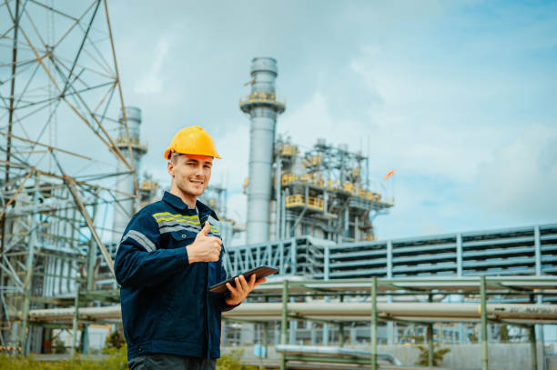 istock Construction worker inspects oil refinery while holding clipboard and giving thumbs up 2196680785