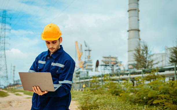 istock Worker in protective gear using laptop at industrial site with machinery in background 2196680787