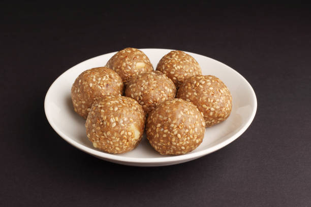 Sesame seed jaggery ball or til ke laddo and tilgul or til gul laddu served in bowl for Makar Sankranti Festival in India