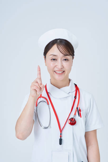 istock A woman in a white coat posing with her index finger up 2196682194