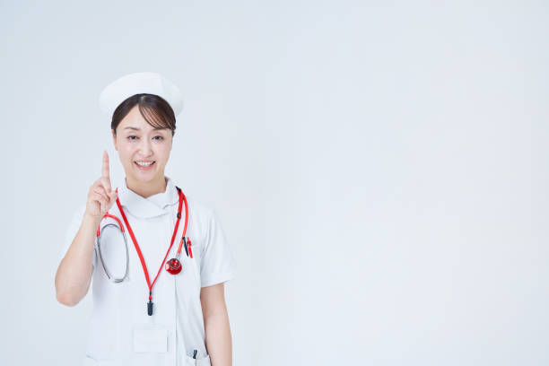 A woman in a white coat posing with her index finger up and white background