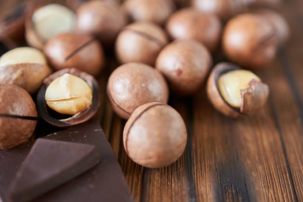 istock Macadamia nuts and chocolate on a wooden table, close-up. Soft focus. 2196682705