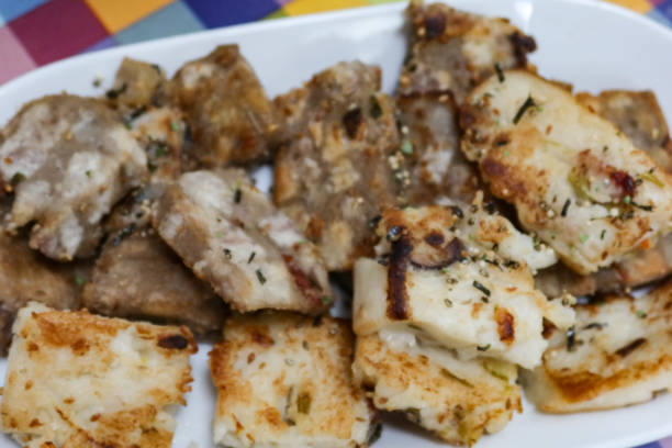 istock Traditional pan fried radish pudding cake and yam pudding cake cut in pieces on a white plate for Chinese Lunar New Year 2196683528