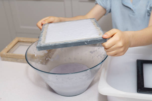 istock boy makes eco-friendly recycled paper at home 2196685710