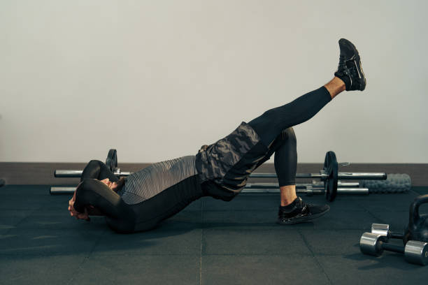 istock Fitness enthusiast performs leg raises on a gym mat during a workout session focusing on core strength and stability 2196687980