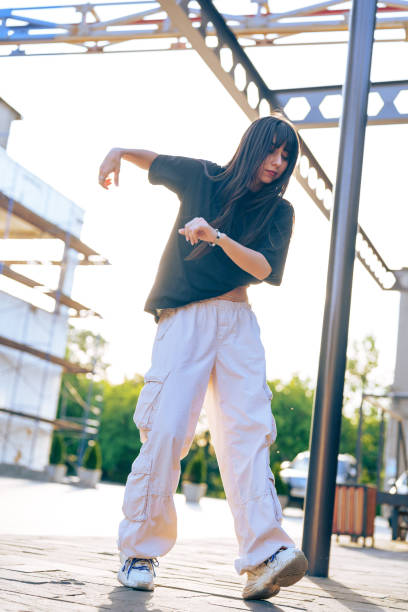 istock Dancer performs expressive movements in a stylish outfit during sunset at an outdoor urban location 2196688560