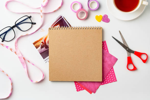 Creative workspace with scrapbook materials and a cup of tea on a bright surface