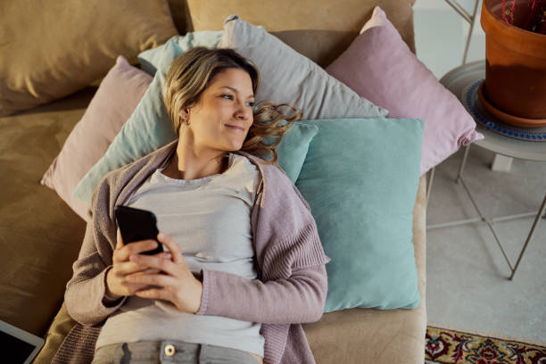 istock Above view of relaxed woman using cell phone at home. 2196691296