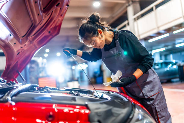 istock Female mechanic checking oil level in car engine 2196694944