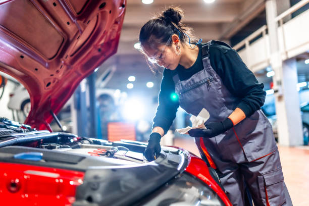 istock Female mechanic checking oil level in car engine at garage 2196694952