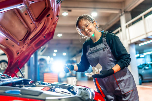 istock Female mechanic checking oil level in car engine at garage 2196694963