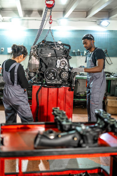 istock Mechanics working on car engine in auto repair shop 2196695313