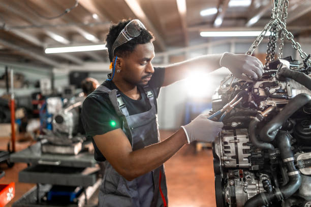 istock Mechanic working on suspended car engine in garage 2196695343