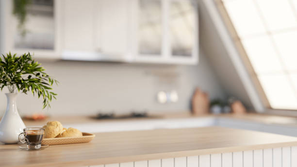 istock A minimalist hardwood kitchen tabletop adorned with decorative items, set in a sleek white kitchen. 2196696346