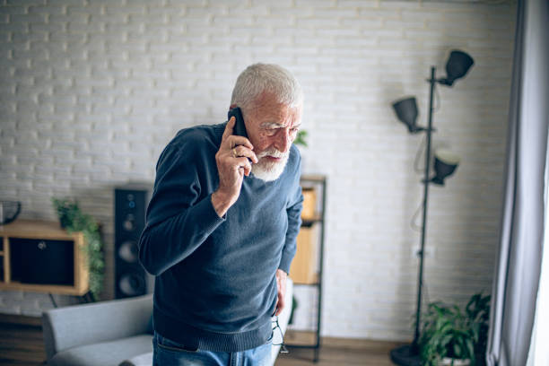 istock Senior man talking on the phone while he is home alone 2196696671